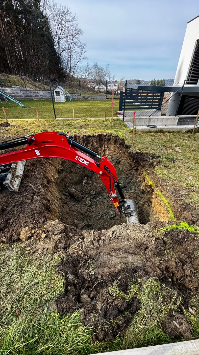 Minibagr při přípravě a srovnání pozemku u rodinného domu