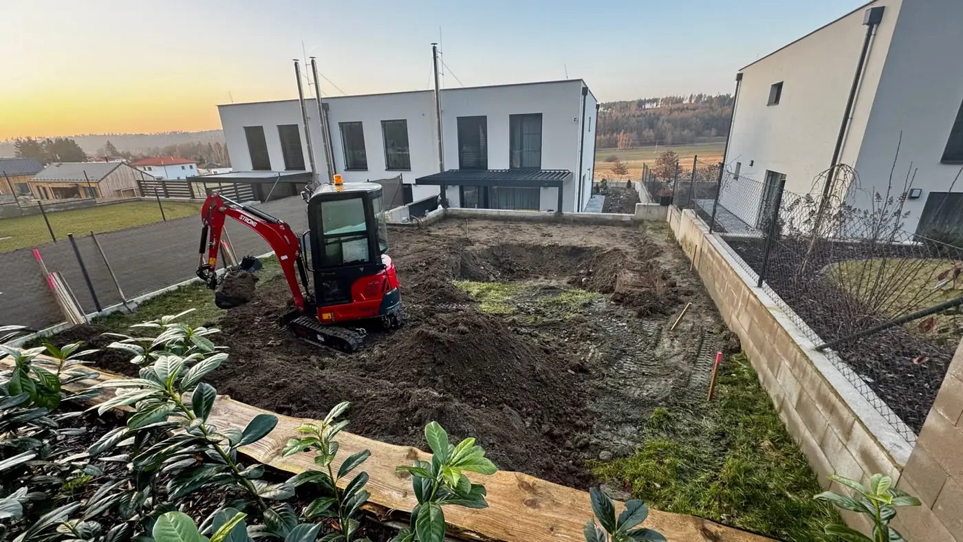 Minibagr při výkopu a úpravě zahrady u novostavby v jižních Čechách